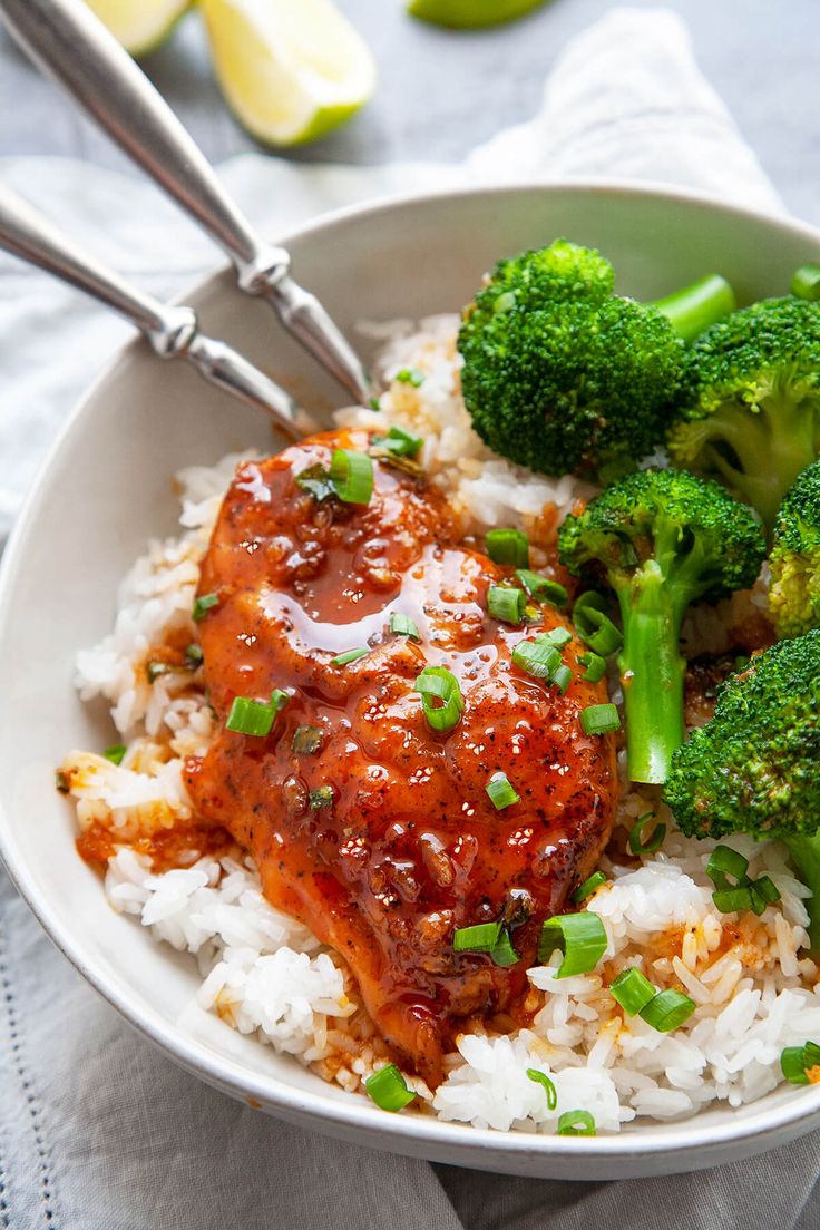 a bowl filled with rice, broccoli and meat covered in sauce on top