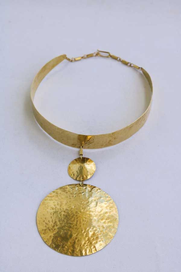 KITUI African brass necklace has a hammered texture hence making it appealing.

Material: Upcycled brass

Processing Time: Ready to ship within 1-3 days

Shipping fee is calculated during checkout

Shipping: DHL Express shipping with 3-5 days delivery

Care instructions:

Brass tarnishes with exposure to moisture and oxidation.

To clean it, kindly use a lemon wedge. Squeeze the juice and polish along the surface with a clean cloth. Gold-tone Brass Round Pendant Necklace, Handmade Brass Gold-tone Necklace, Handmade Brass Necklace In Gold-tone, Handmade Gold-tone Brass Necklace, Gold-tone Brass Jewelry With Large Pendant, Handmade Gold Brass Necklace, Vintage Brass Choker Necklace, Gold Hammered Brass Coin Necklace, Adjustable Gold-tone Brass Necklaces