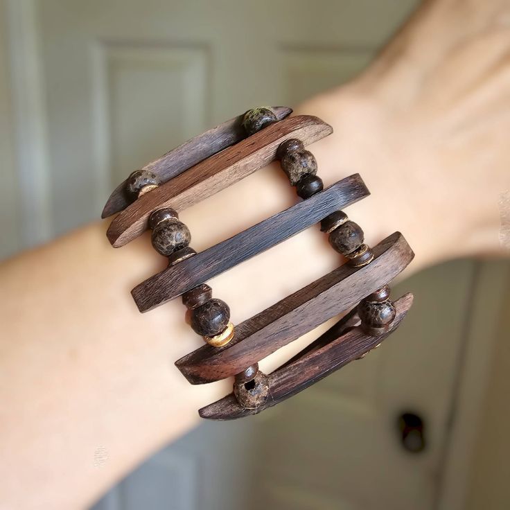 Lightweight stretch bracelet, wooden segmented and round beaded style. Bracelet makes a great gift. The bracelet is made from Balinese light wood. They are very strong and hard wearing. Brown colour. Bracelet stretches, so fits most ladies, and 19 cm L by 8.5 cm W cm. This bracelet would also make an excellent present for nature enthusiasts, eco conscious fashionistas, or anybody who enjoys the beauty of handcrafted accessories. Add this one of a kind wooden bracelet to your collection today and enjoy its eternal beauty and charm! All our products from Bali were designed by myself and made by our fair trade partners who directly benefit from your orders We are proud to offer it at a very reasonable price as always with us there is no middleman Please visit my other Etsy shop, Rosa Azul Cra Festival Hand Wrapped Bangle Bracelet, Artisan Fair Trade Bracelets For Beach, Artisan Adjustable Bangle For Festivals, Artisan Adjustable Bangle Bracelets, Adjustable Wrap Bangle Bracelet, Fair Trade Bracelet Jewelry For Festivals, Adjustable Unique Wrap Bangle Bracelet, Unique Adjustable Wrap Bangle Bracelet, Fair Trade Festival Bracelet Jewelry