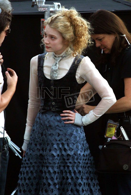 a woman in a blue dress standing next to a man on the set of a movie