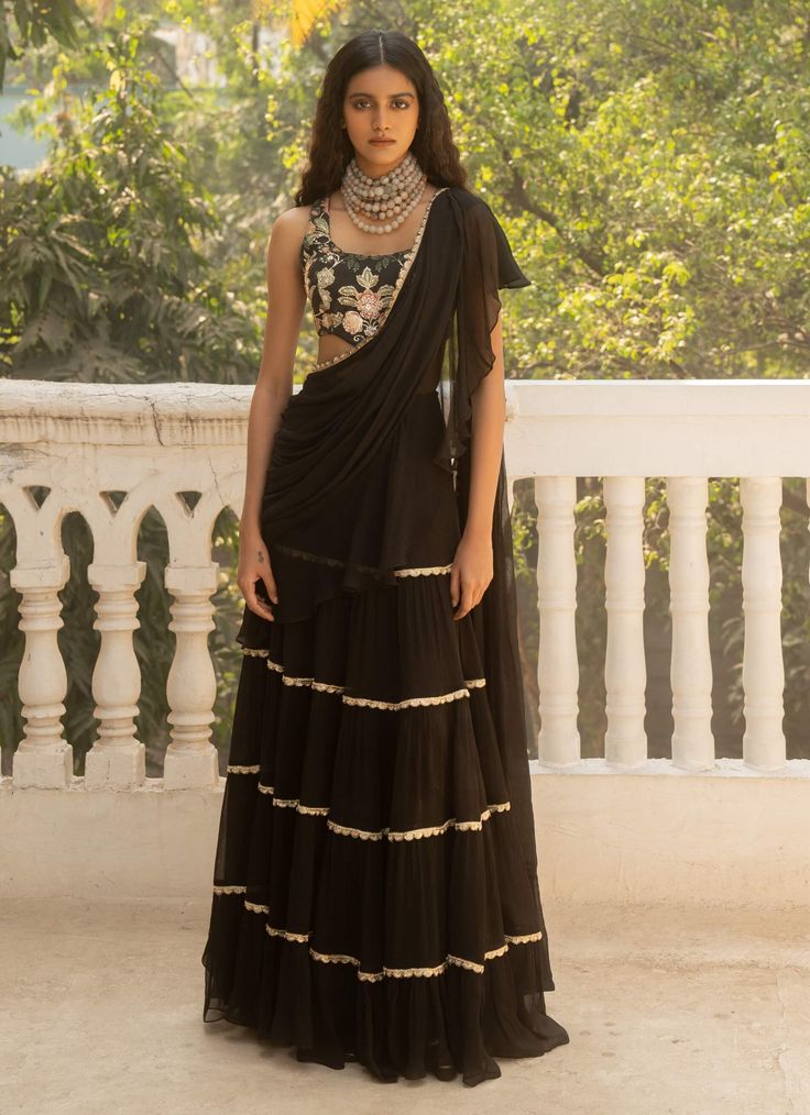 Elevate your style with this black pre-stitched chiffon sari, crafted from pure chiffon and adorned with elegant lace detailing. Paired with a print-embroidered corset blouse, this ensemble offers a chic and sophisticated look. Silk Chiffon Pre-draped Saree With Sheer Dupatta, Festive Pre-draped Saree With Lace Work, Traditional Chiffon Pre-draped Saree For Party, Elegant Black Organza Pre-draped Saree, Black Georgette Pre-draped Saree With Resham Embroidery, Black Pre-draped Saree With Zari Work, Elegant Pre-draped Saree With Sheer Dupatta In Silk Chiffon, Elegant Pre-draped Silk Chiffon Saree With Sheer Dupatta, Chiffon Pre-draped Saree For Evening