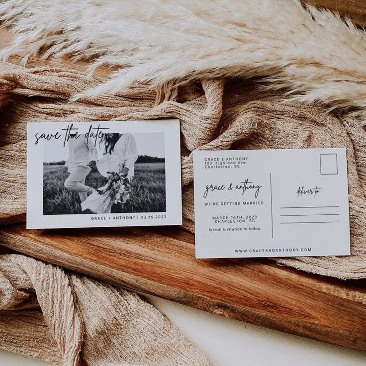 two wedding postcards sitting on top of a wooden board next to a fur rug