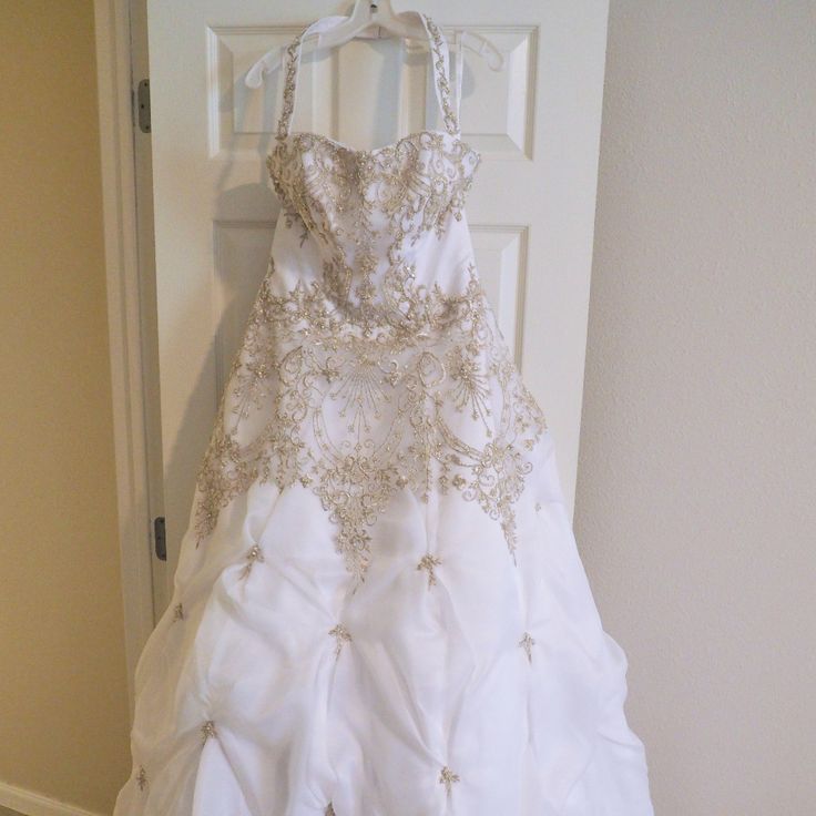 a wedding dress hanging on a door