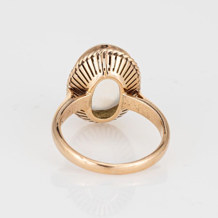 This is part of Chairish’s Fine Jewelry assortment.  Stylish mid-century moonstone cocktail ring crafted in 18 karat yellow gold.   Cabochon moonstone measures 12mm x 10mm. The moonstone is in very good condition and free of cracks or chips.   The beautiful luminous moonstone glows with every movement of the ring. The medium sized cocktail ring is bordered with rope detailing and makes a nice statement on the hand. The medium rise ring (9mm - 0.35 inches) sits comfortably on the finger.   The ri Yellow Gold Oval Cabochon Moonstone Ring, Classic Yellow Gold Oval Cabochon Moonstone Ring, Vintage Oval Moonstone Ring With Polished Finish, Formal Oval Cabochon Moonstone Ring, Heirloom Yellow Gold Moonstone Cabochon Ring, Hallmarked Yellow Gold Moonstone Ring, Classic Yellow Gold Cabochon Moonstone Ring, Vintage Oval Cabochon Moonstone Ring, Fine Jewelry Yellow Gold Oval Cabochon Moonstone Ring