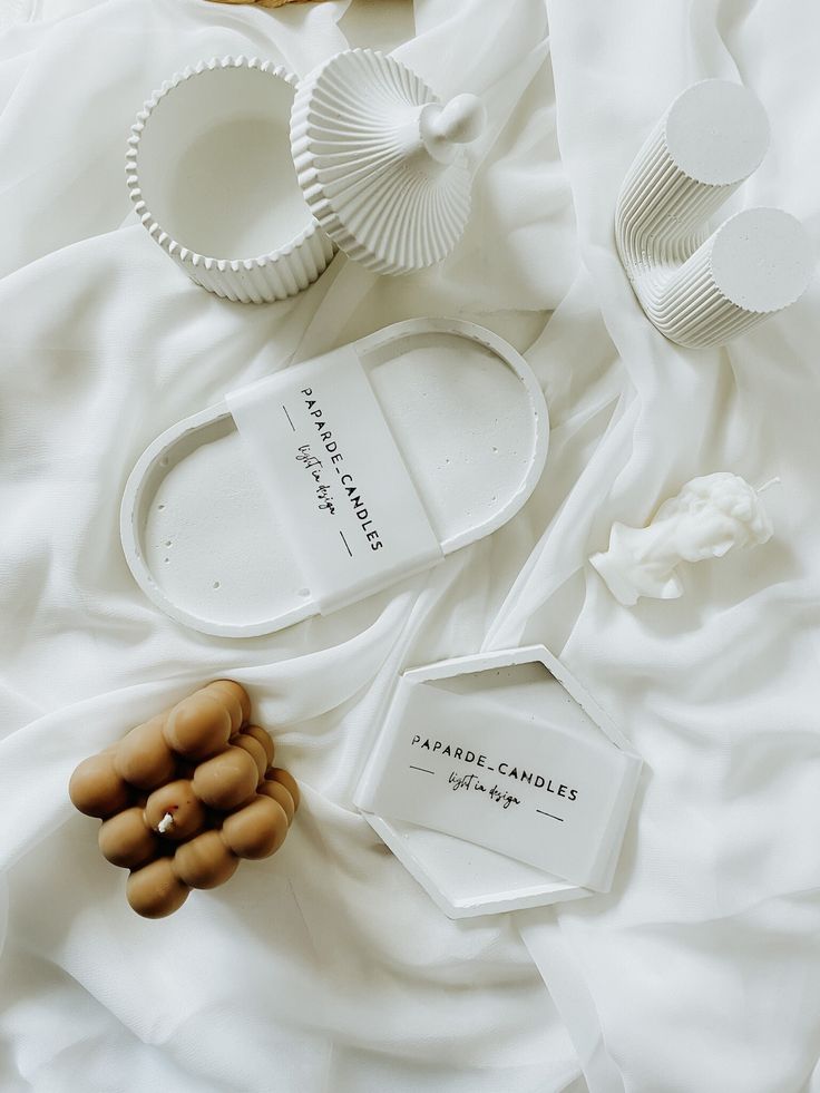 the contents of a white bed spread out on top of each other, including soaps and toothbrushes