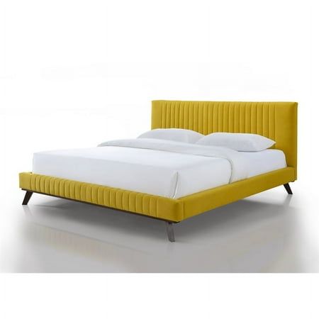 a bed with yellow upholstered headboard and white sheets on the bottom side