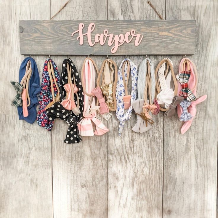 a wooden sign that says hanger with many different bows hanging from it