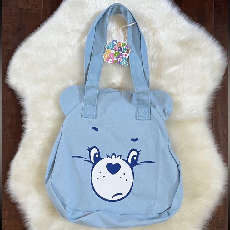 New With Tags Women's Care Bears Grumpy Bear Shoulder Bag Casual Light Blue Everyday Bag, Playful Blue Bag With Adjustable Strap, Playful Blue Shoulder Bag For School, Light Blue School Bag For Summer, Blue Trendy Canvas Bag For Everyday Use, Light Blue Cotton Bag For Everyday Use, Light Blue Cotton Bag For Daily Use, Trendy Blue Canvas Bag For Everyday Use, Light Blue Cotton Bags For Everyday Use