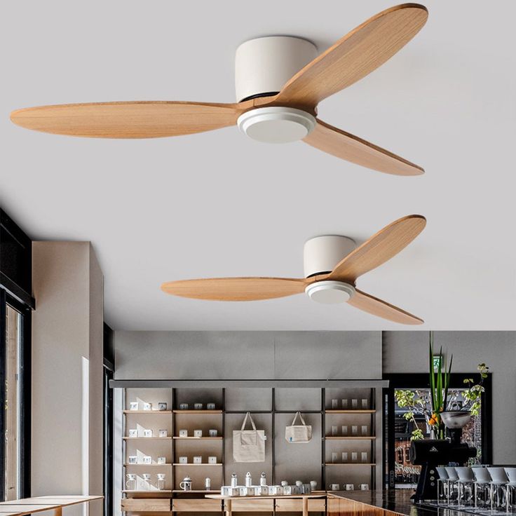 two ceiling fans are hanging from the ceiling in a room with wooden tables and chairs