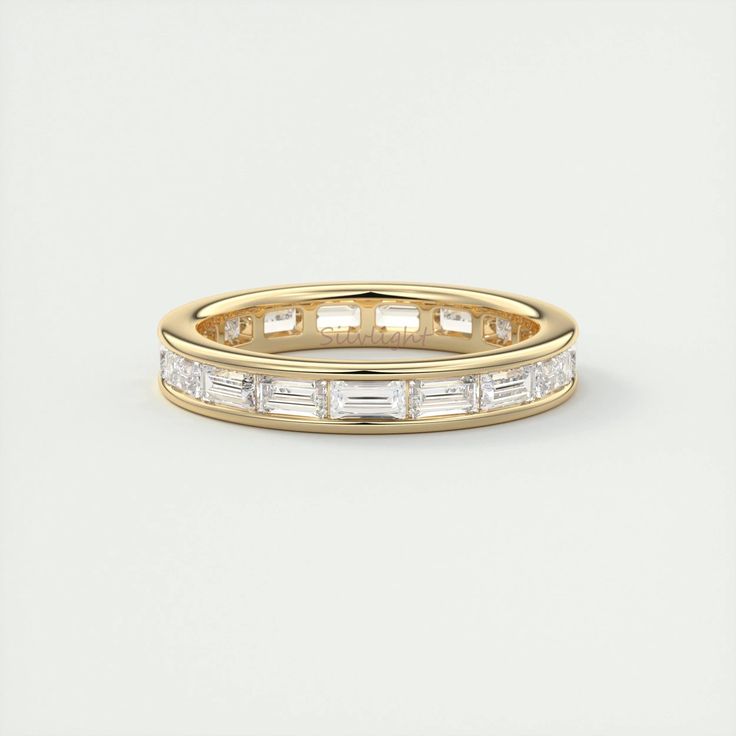 a yellow gold wedding band with baguettes on the side and sides in white diamonds