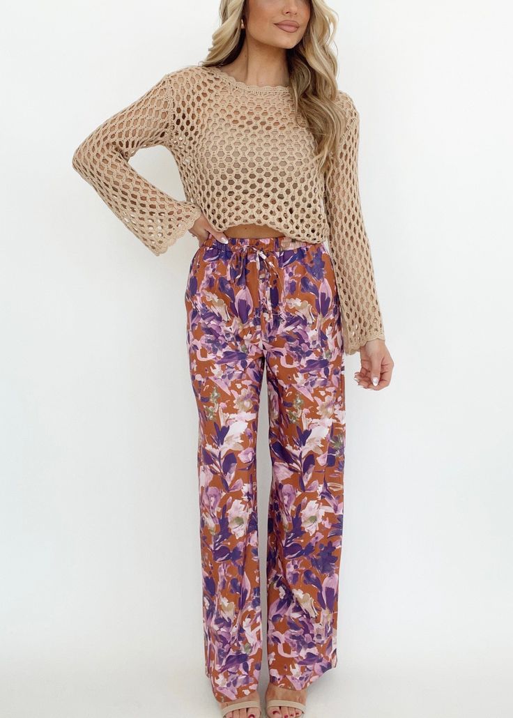 Experience the beauty and vibrance of the tropics with our Ibiza Moonlight Pants. The bold floral print adds a pop of color to your wardrobe, while the high waisted and straight leg design provide a flattering silhouette. Perfect for any occasion, from resort dinners to drinks with friends, these pants offer both comfort and style. Featuring pocket details, stretchy elastic waistband, and an adjustable drawstring, they are as versatile as they are trendy. So whether you're on vacation or simply Floral Print Summer Bottoms For Brunch, Summer Floral Print Wide-leg Pants, Bohemian Floral Print Bottoms For Beach Season, Floral Print Wide Leg Pants For Vacation In Spring, Floral Wide Leg Pants For Vacation In Spring, Summer Wide Leg Floral Print Pants, Summer Wide Leg Pants With Floral Print, Bohemian Beach Season Floral Bottoms, Vibrant Wide Leg Spring Pants