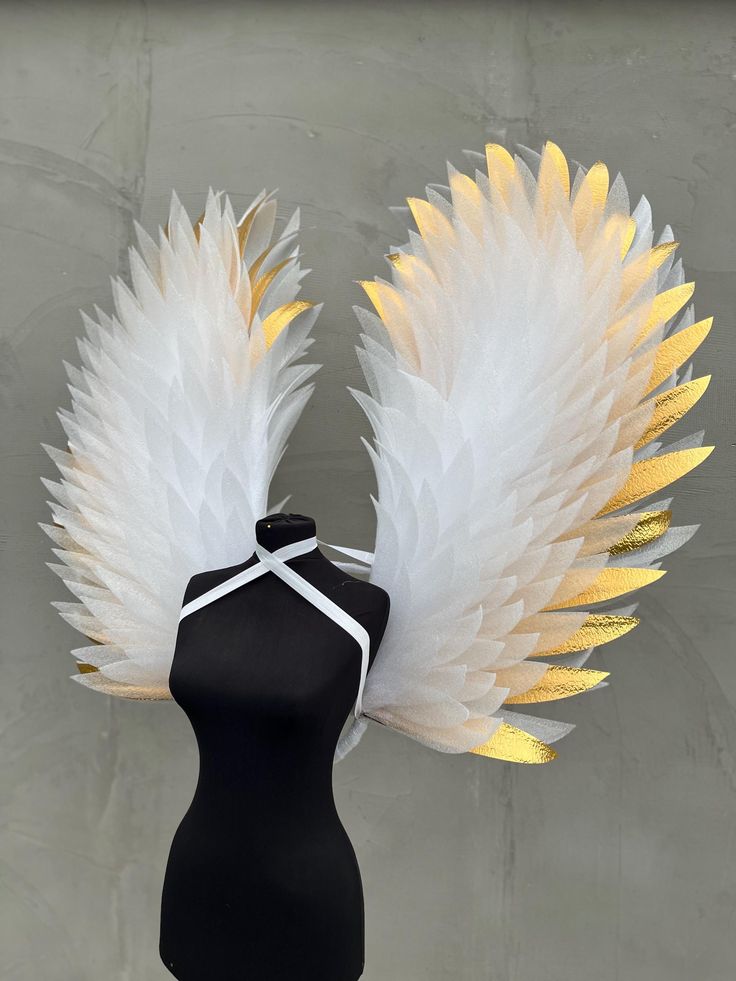 a black mannequin with white and yellow feathers on it