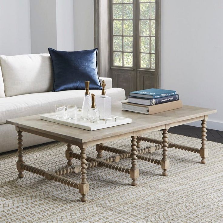 a living room with a couch, coffee table and two books on the side tables