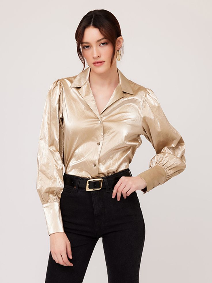 Exude confidence and charisma as you shimmer in the light creating a radiant and luxurious look with this beautiful top. Crushed Metallic: 50% Polyurethane 35% Viscose 7% Acrylic 5% Cotton 3% Metallic Made in USA Hand wash cold water. Hang to dry Length: 23 inches (size S) Notched collar Button up Shell buttons Style number: 4F19046 Chic Fall Tops With Sheen, Chic Sheen Tops For Fall, Chic Shiny Tops For Fall, Glamorous Shiny Tops For Spring, Trendy Gold Blouse For Night Out, Glamorous Button-up Tops For Fall, Chic Fitted Shiny Tops, Chic Spring Top With Sheen, Fitted Shiny Chic Tops