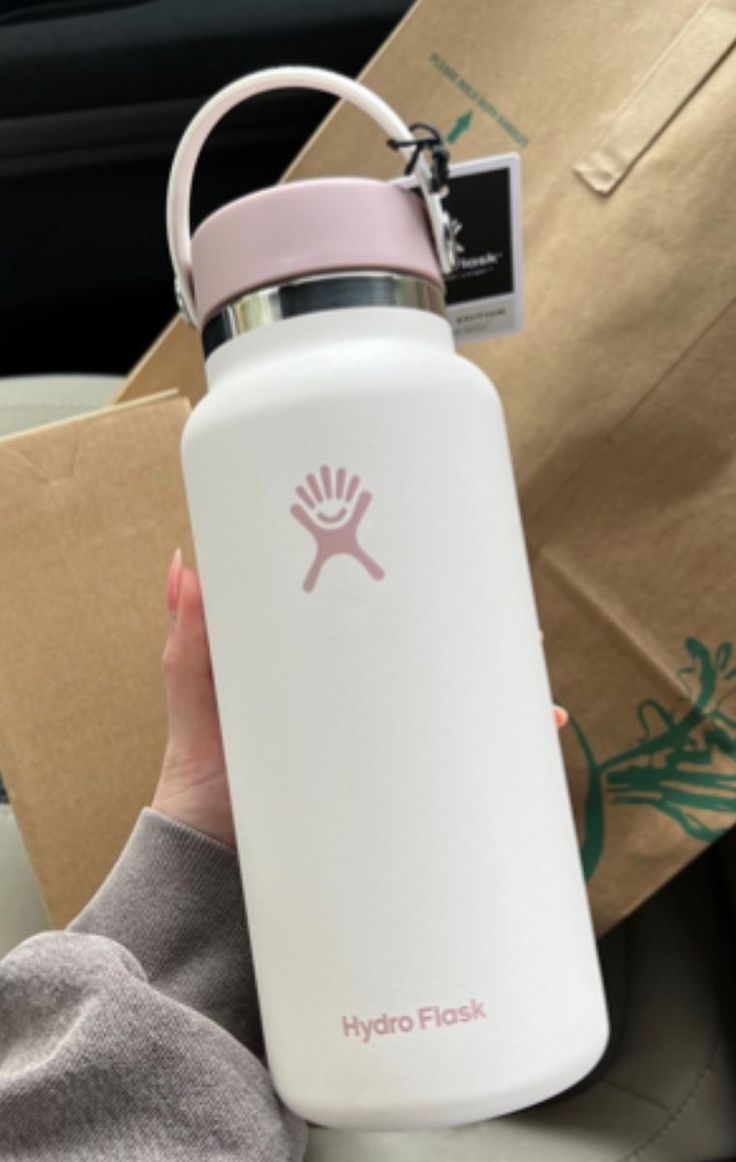 a person holding a hydro flask in their hand