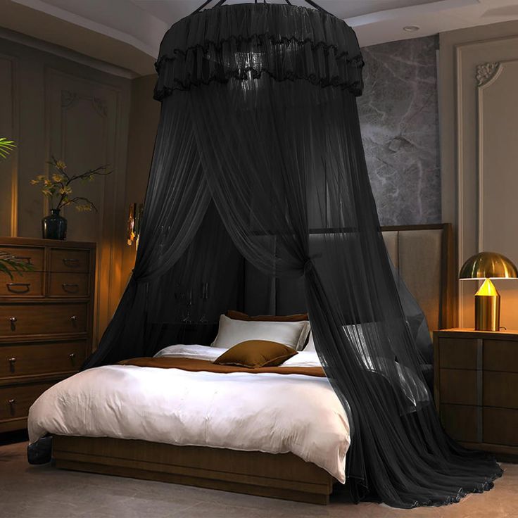 a bed with a black canopy over it in a bedroom next to a dresser and lamp