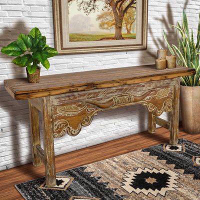 a wooden table sitting next to a potted plant