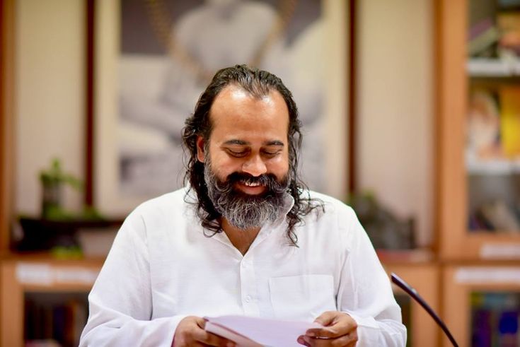 a man with long hair and beard holding a piece of paper in front of him