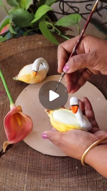 a person is decorating some flowers with clay