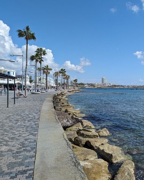 the beach is lined with palm trees and stone walkways that lead to the water