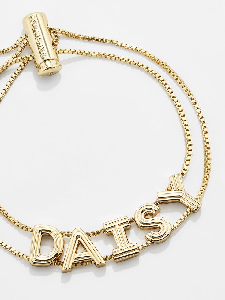 For those who love gold, our Custom Slider Bracelet: Textured Gold is the custom bracelet pick for you. Two strands of box chain sit beneath letter beads of your choice and are topped off with an easy-to-adjust pull-tie closure. Even better? Each bead is crafted in a chic gold hue and features etched grooves, giving each letter extra dimension. Choose a name, initials, or favorite phrase to customize your bracelet with - it's sure to be your new everyday staple. See our Letter Key for all option Adjustable Gold-tone Charm Bracelet Gift, Gold Charm Bracelet With Adjustable Length, Gold Charm Bracelet With Adjustable Length As Gift, Adjustable Gold-tone Box Chain Bracelet, Gold Friendship Bracelets With Adjustable Length, Gold-tone Box Chain Bracelet For Gift, Adjustable Yellow Gold Chain Bracelet For Friendship, Gold Letter Beads Charm Bracelet For Friendship, Adjustable Nameplate Bracelets For Friendship