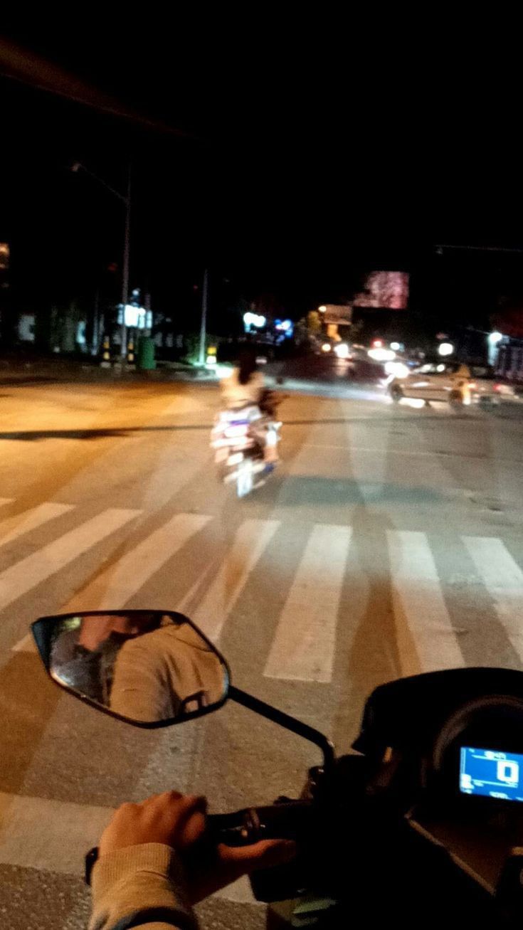 a person riding a motorcycle down a street at night