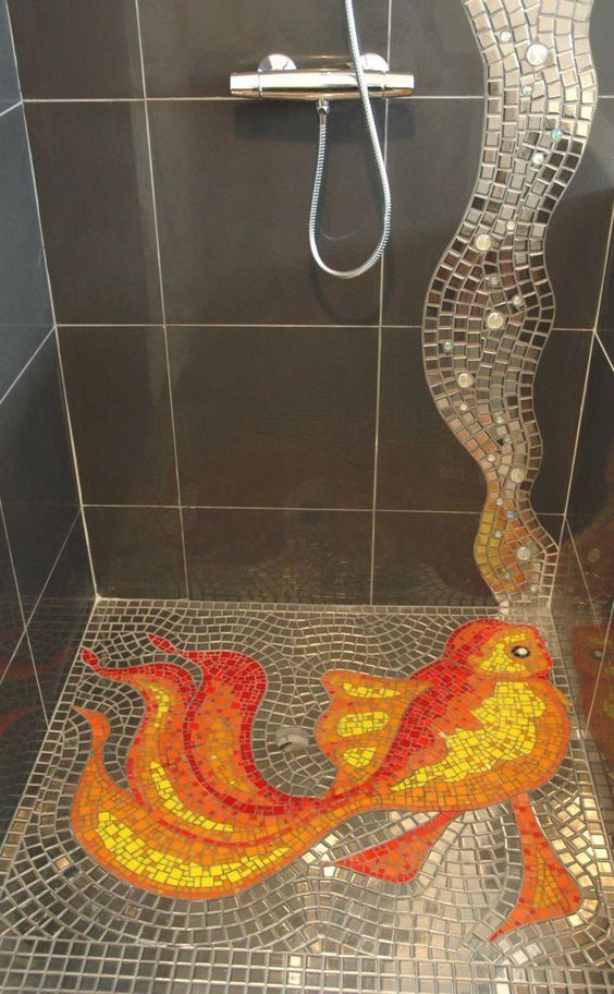 a mosaic shower with a fish on the floor