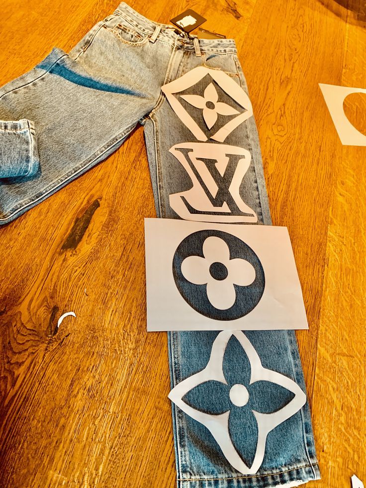 some cut out pieces of clothing sitting on top of a wooden table