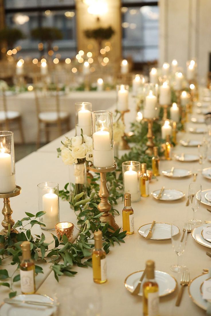 a long table with candles and plates on it