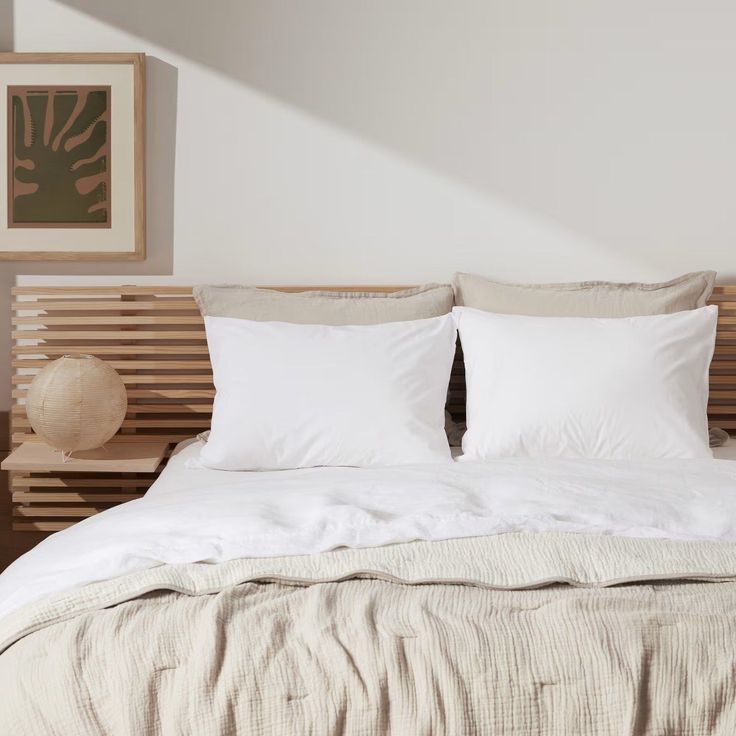 a bed with two pillows and white sheets