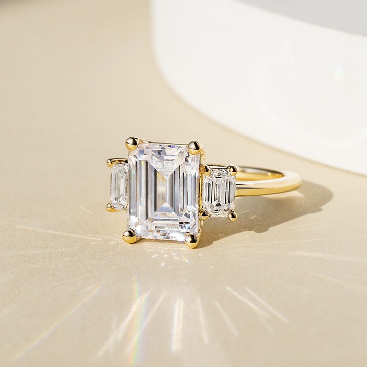 an engagement ring with three emerald cut diamonds