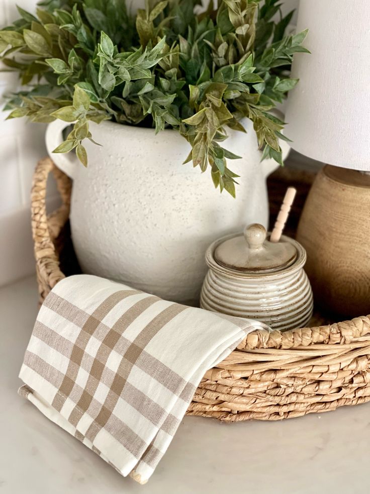 a basket with a lamp, potted plant and other items on top of it