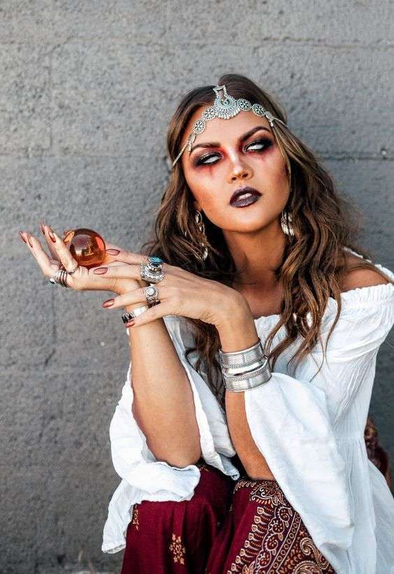 a woman in white shirt and red skirt holding up a donut with makeup on it