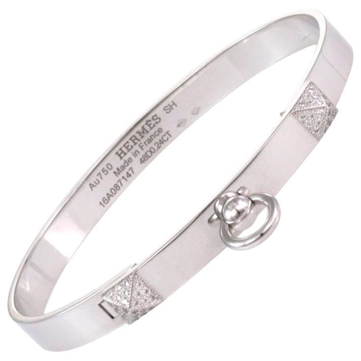 This stunning Collier de Chein collection is by Hermes, it features an authentic bangle crafted from 18k white gold with a high polished finish featuring a 6mm wide band. The front of the bangle has two small pyramid like design set with diamond and the center has a door knocker ring dangling below. It is signed by the designer with the serial number, gold content and diamond weight. Brand: Hermes Hallmark: Au750 Hermes SH Made in France 16A087147 48D0.24ct Diamond: 0.24ct (48 diamonds) Material Formal Engraved White Gold Bangle, Luxury White Gold Engraved Cuff Bracelet, Luxury Engraved White Gold Cuff Bracelet, Luxury Diamond Bangle With Polished Finish, Luxury Hallmarked White Gold Cuff Bracelet, Luxury Platinum Diamond Bracelet With Polished Finish, Designer White Gold Bracelets With Brilliant Cut, Designer White Gold Bracelet With Brilliant Cut, Designer White Gold Diamond Bangle Bracelet