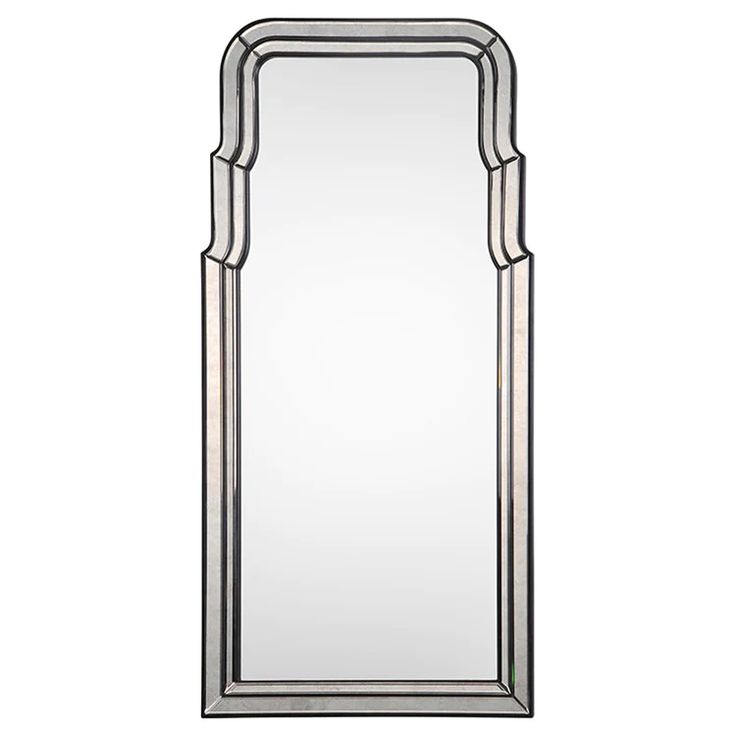 a large mirror with silver trimmings on the sides and an arched frame around it