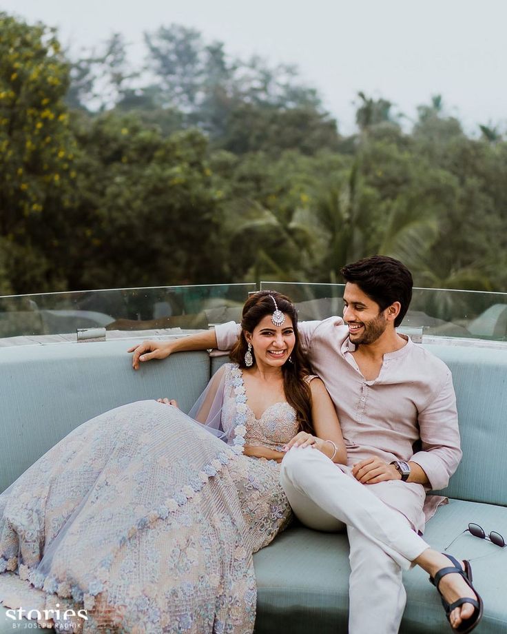 a man and woman sitting on top of a blue couch