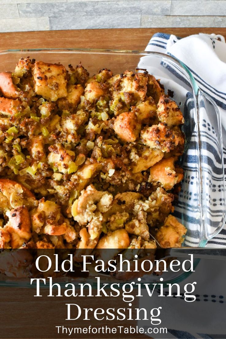 an old fashioned thanksgiving stuffing in a glass dish with a fork and napkin on the side