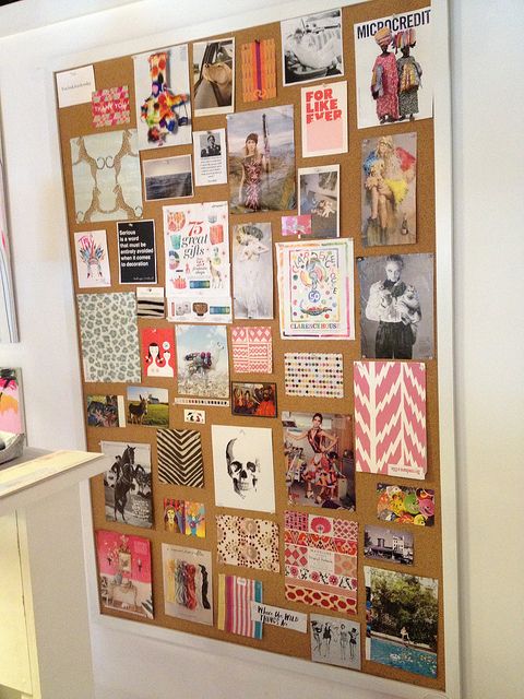 a cork board with pictures and magnets attached to it on the wall next to a counter