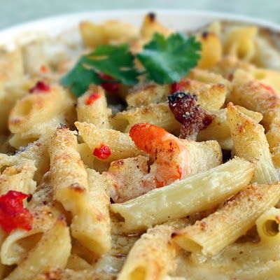 a white plate topped with pasta covered in sauce and garnished with parsley