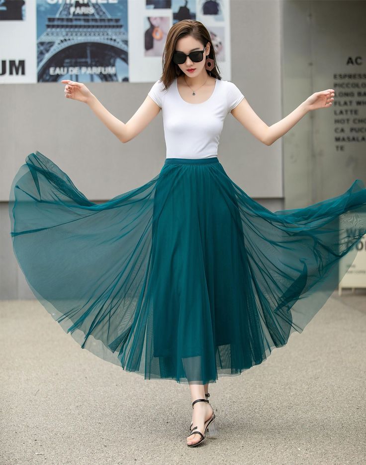 "This blue tulle swing skirt is perfect for any occasion! The lightweight fabric flows beautifully, and the pleated design adds a playful touch. Whether you dress it up for a night out or keep it casual with sandals, this skirt is sure to become a go-to in your wardrobe. DETAILS: * Tulle Skirt * No Pockets * Around elastic waistband * Circle Skirt * Big swing skirt * Perfect for spring, summer * Suit vacation, beach, dance etc. * Machine Washable in Warm/Cold Water; Do not bleach / Mid-iron / Ha Summer Flared Tulle Maxi Skirt, Summer Tulle Maxi Flared Skirt, Spring Chiffon Tulle Skirt, Summer Long Tulle Pleated Skirt, Green Tulle Bottoms For Summer, Summer Flowy Tulle Pleated Skirt, Flowy Blue Party Skirt, Blue Flowy Party Skirt, Blue Flowy Skirt For Party