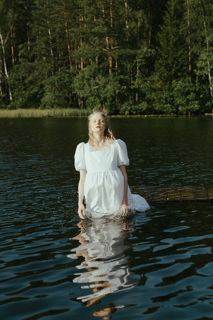 a woman standing in the middle of a lake