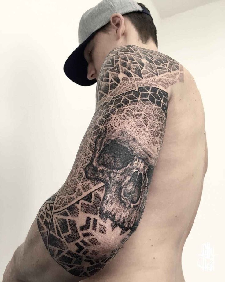 a man with a skull tattoo on his arm