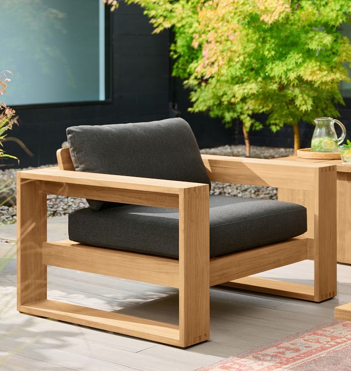 a chair sitting on top of a wooden floor next to a table with a vase