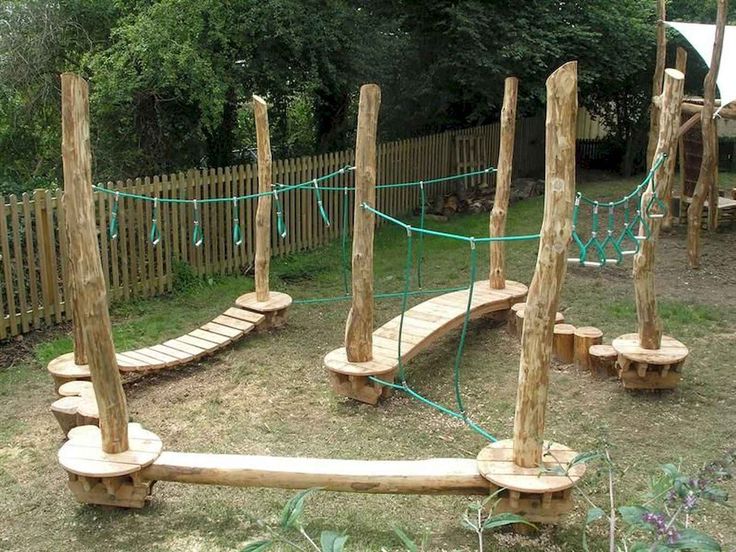 an outdoor play area made out of logs and ropes