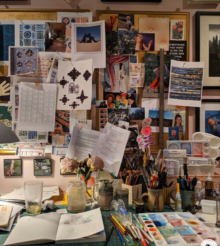 a cluttered desk with many pictures on the wall