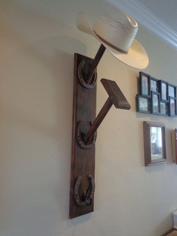 a cowboy hat hanging on the side of a wall next to pictures and framed photos