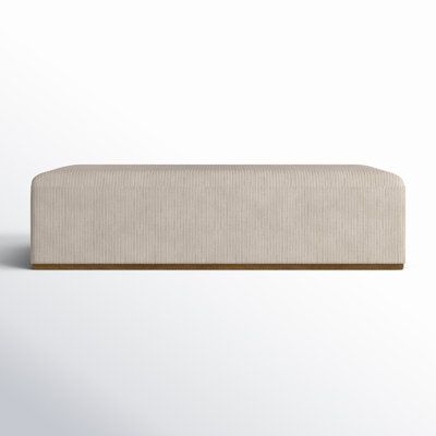 an upholstered bench with a wooden frame on the top and bottom, against a white background