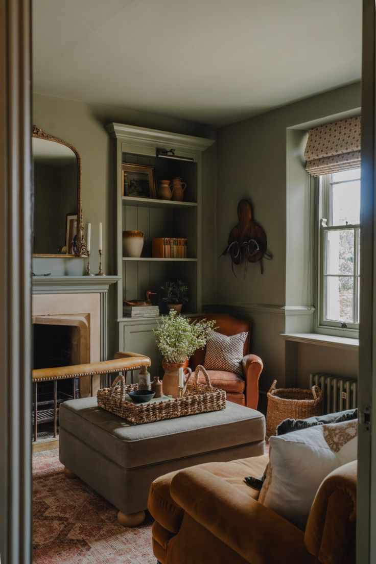 a living room filled with furniture and a fire place under a window next to a fireplace