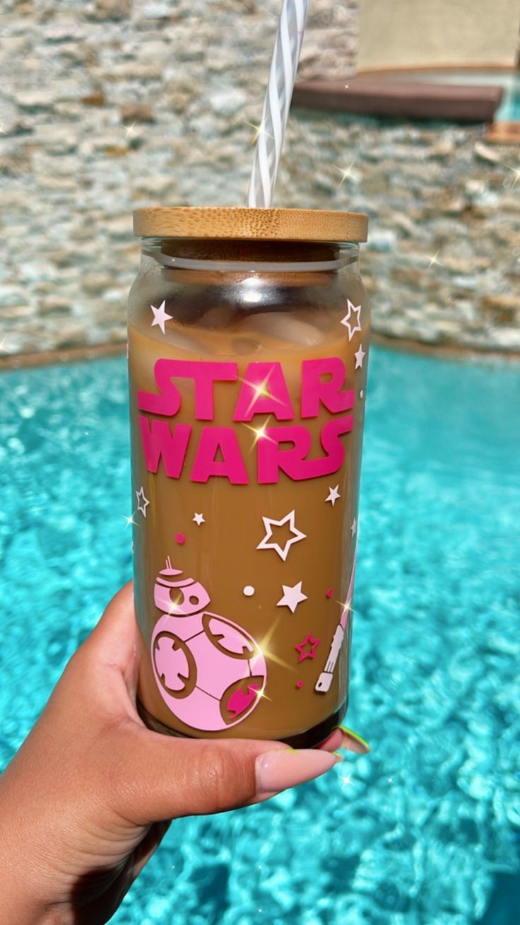 someone holding up a star wars tumbler in front of a swimming pool with stars on it