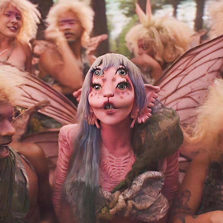 a group of people dressed up as fairy land characters with their faces painted pink and green